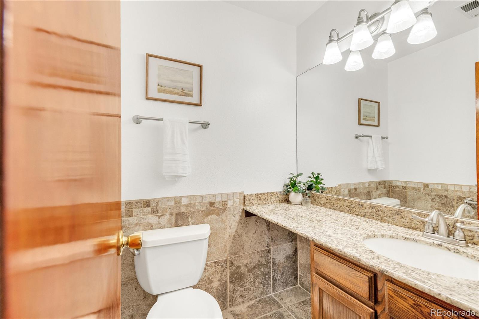 5210 Estes Circle Arvada, CO 80002 - Photo 18 of 29 a bathroom with a granite countertop toilet sink and mirror