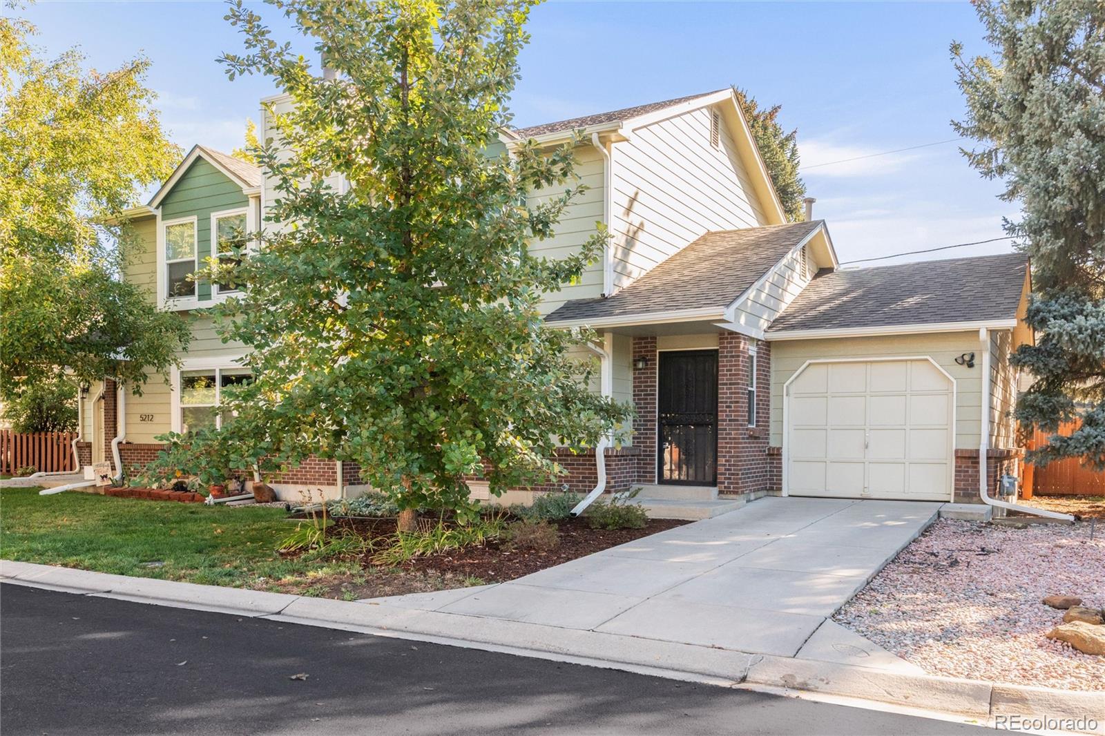5210 Estes Circle Arvada, CO 80002 - Photo 2 of 29 a front view of a house with a garden