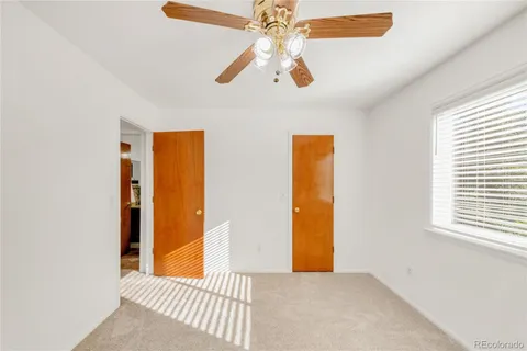 a view of a room with a ceiling fan and a window