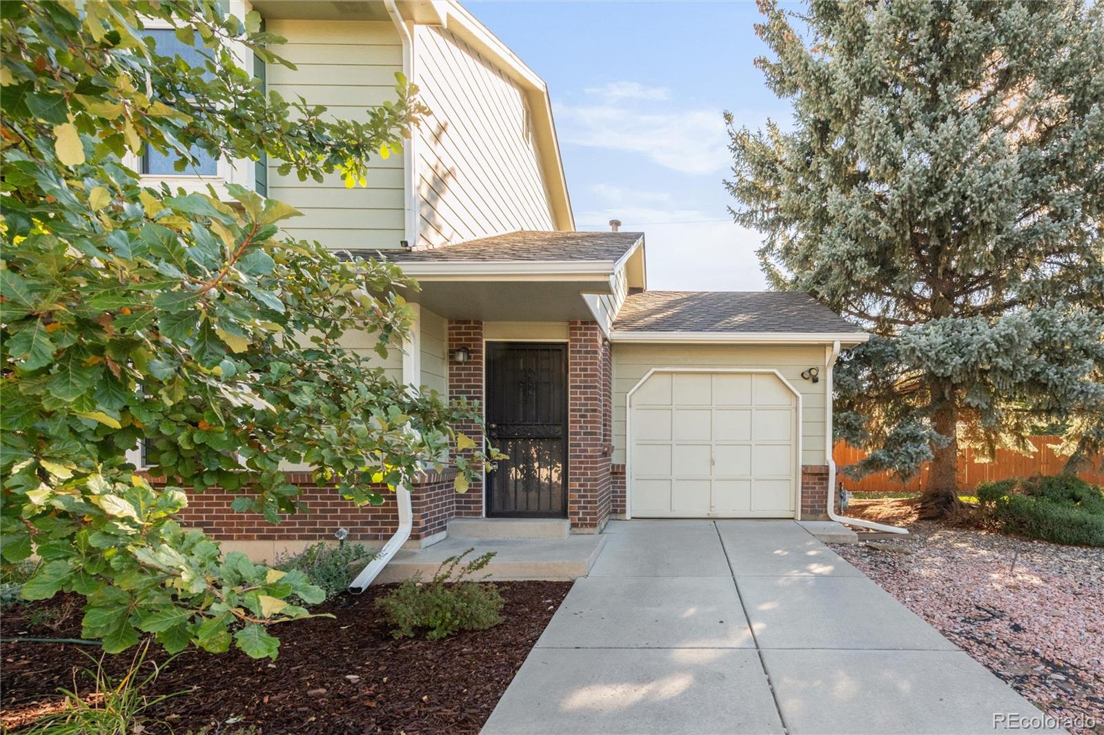 5210 Estes Circle Arvada, CO 80002 - Photo 3 of 29 a front view of a house with a yard and garage
