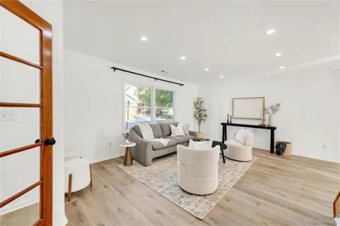 a living room with furniture a window and wooden floor