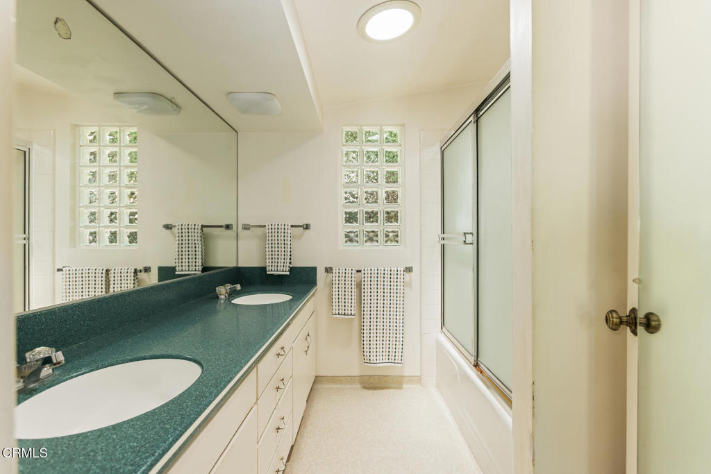 5029 Princess Anne Road La Canada Flintridge, CA 91011 - Photo 22 of 46 a bathroom with a granite countertop sink a toilet a mirror and shower