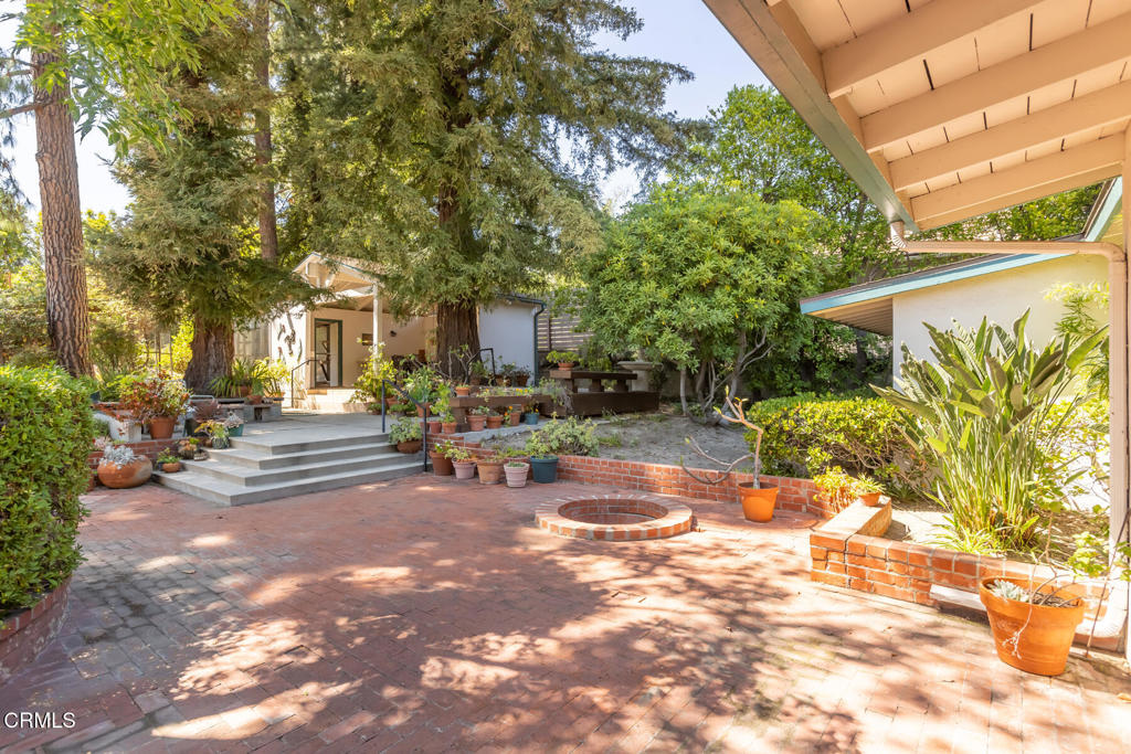 5029 Princess Anne Road La Canada Flintridge, CA 91011 - Photo 40 of 46 a view of patio with couches and table and chairs under an umbrella with large trees
