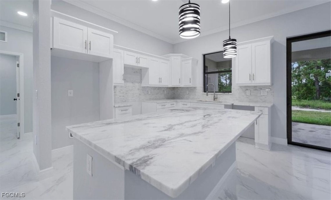 3208 3rd Street Southwest Lehigh Acres, FL 33976 - Photo 13 of 31 a kitchen with kitchen island granite countertop a sink a counter top space appliances and cabinets