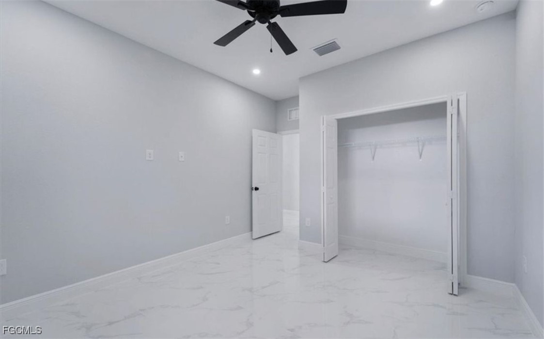 3208 3rd Street Southwest Lehigh Acres, FL 33976 - Photo 14 of 31 an empty room with a ceiling fan and carpet