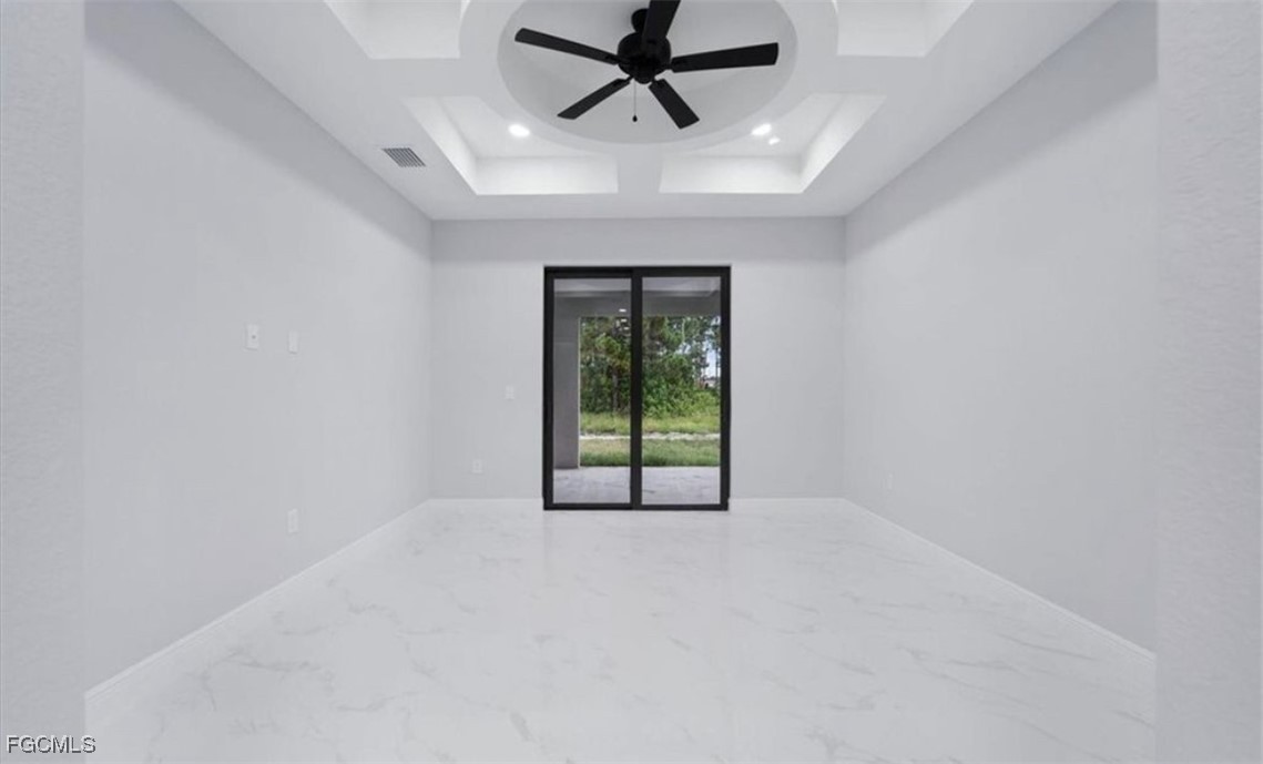 3208 3rd Street Southwest Lehigh Acres, FL 33976 - Photo 17 of 31 an empty room with windows and ceiling fan