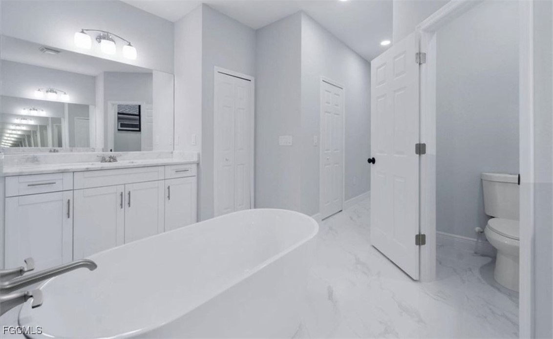 3208 3rd Street Southwest Lehigh Acres, FL 33976 - Photo 21 of 31 a spacious bathroom with a tub sink toilet and mirror