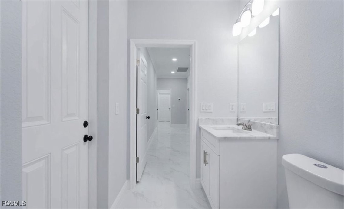 3208 3rd Street Southwest Lehigh Acres, FL 33976 - Photo 26 of 31 a bathroom with a toilet sink and mirror