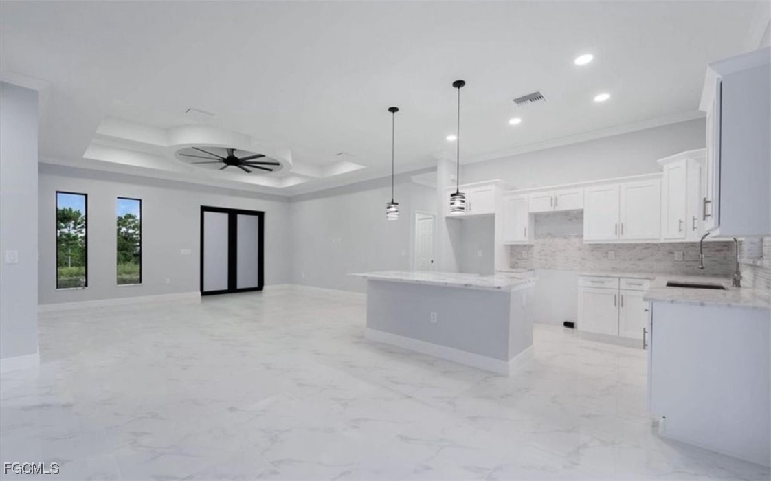 3208 3rd Street Southwest Lehigh Acres, FL 33976 - Photo 30 of 31 a large white kitchen with kitchen island a sink stainless steel appliances and cabinets