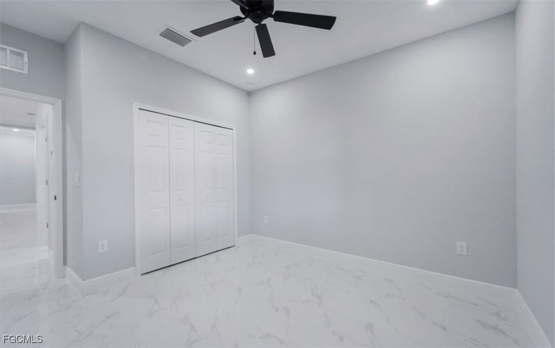 3208 3rd Street Southwest Lehigh Acres, FL 33976 - Photo 8 of 31 an empty room with a ceiling fan and carpet