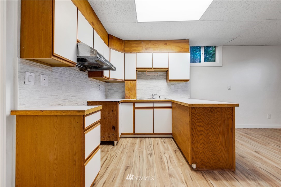 1433 South Hinds Street Seattle, WA 98144 - Photo 33 of 40 a kitchen with stainless steel appliances granite countertop a sink a stove top oven a counter space and cabinets