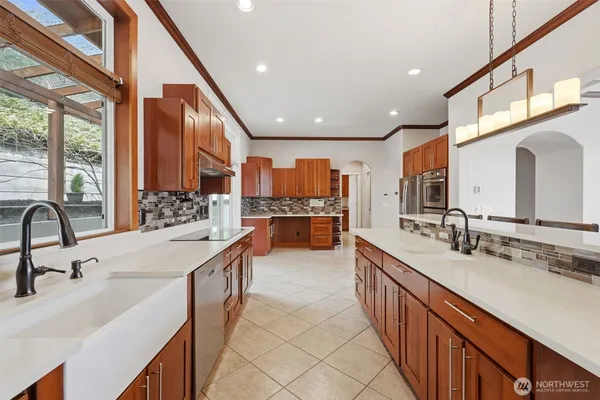 a large kitchen with stainless steel appliances a sink and a large window