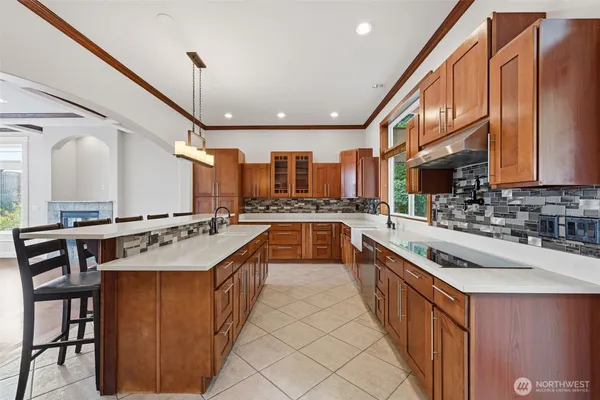 a kitchen with stainless steel appliances granite countertop a sink a stove and a wooden floors