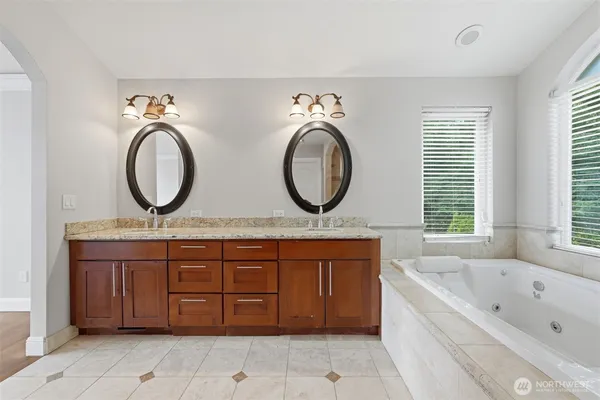 a bathroom with a granite countertop double vanity sink and a mirror