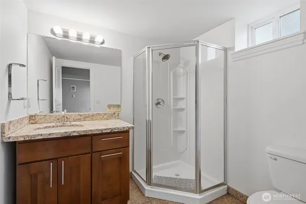 a bathroom with a granite countertop sink a mirror and a shower