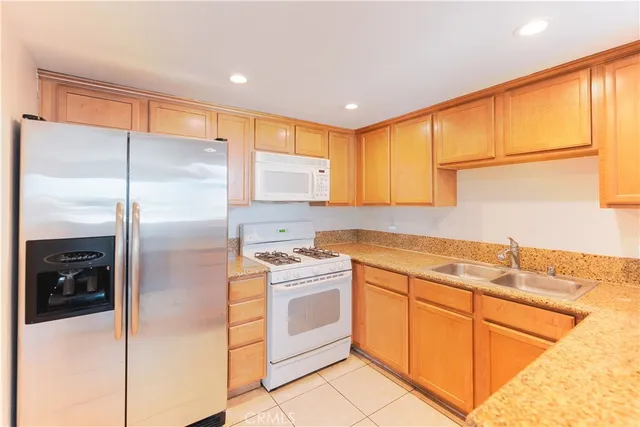 a kitchen with a refrigerator sink and cabinets