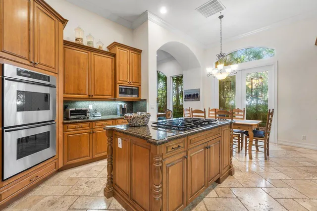 a kitchen with stainless steel appliances granite countertop a stove a sink and a refrigerator