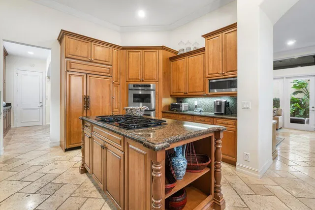 a kitchen with stainless steel appliances granite countertop a stove a sink and a refrigerator
