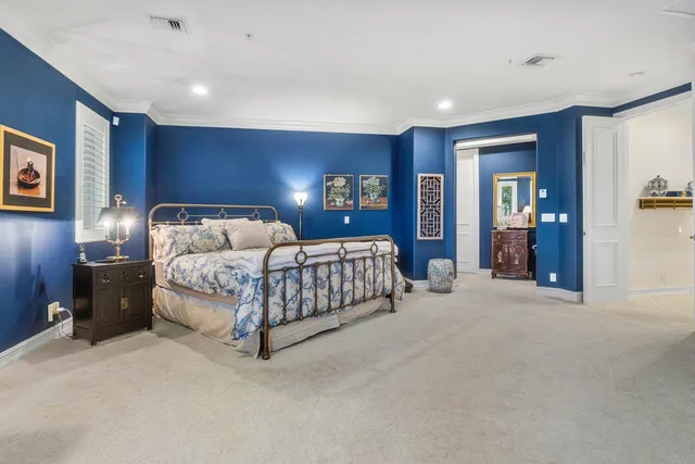 a bedroom with a bed and painting on the wall