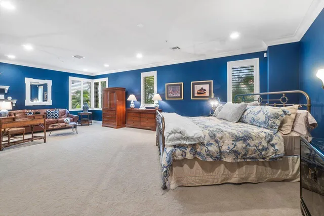 a bedroom with a large bed couch and a window