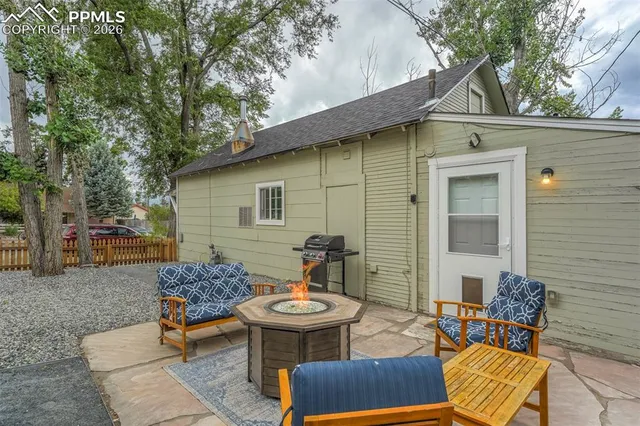 a view of a patio with table and chairs with wooden floor and fence