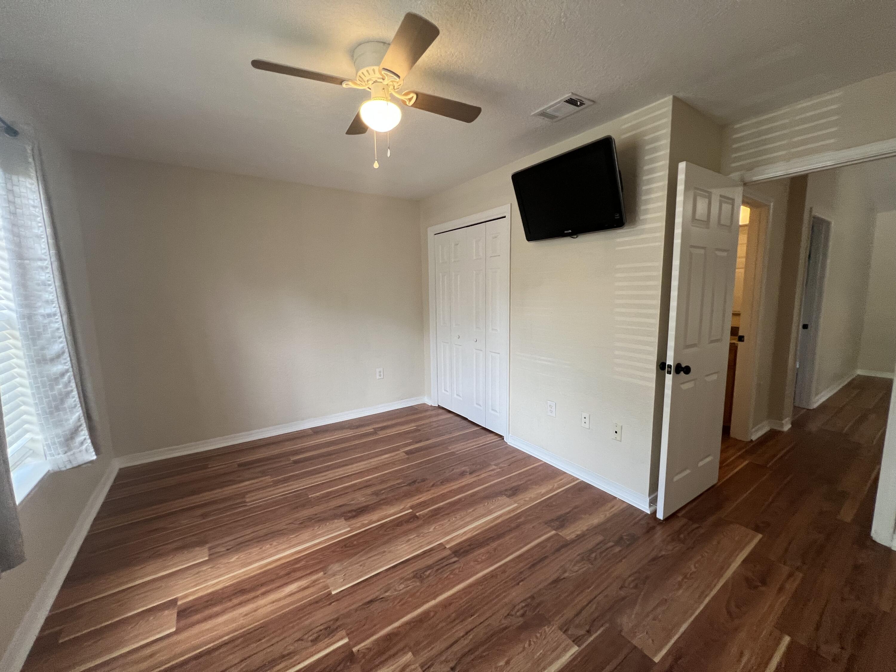 2864 Shoffner Avenue Crestview, FL 32539 - Photo 12 of 29 a view of empty room with wooden floor and fan