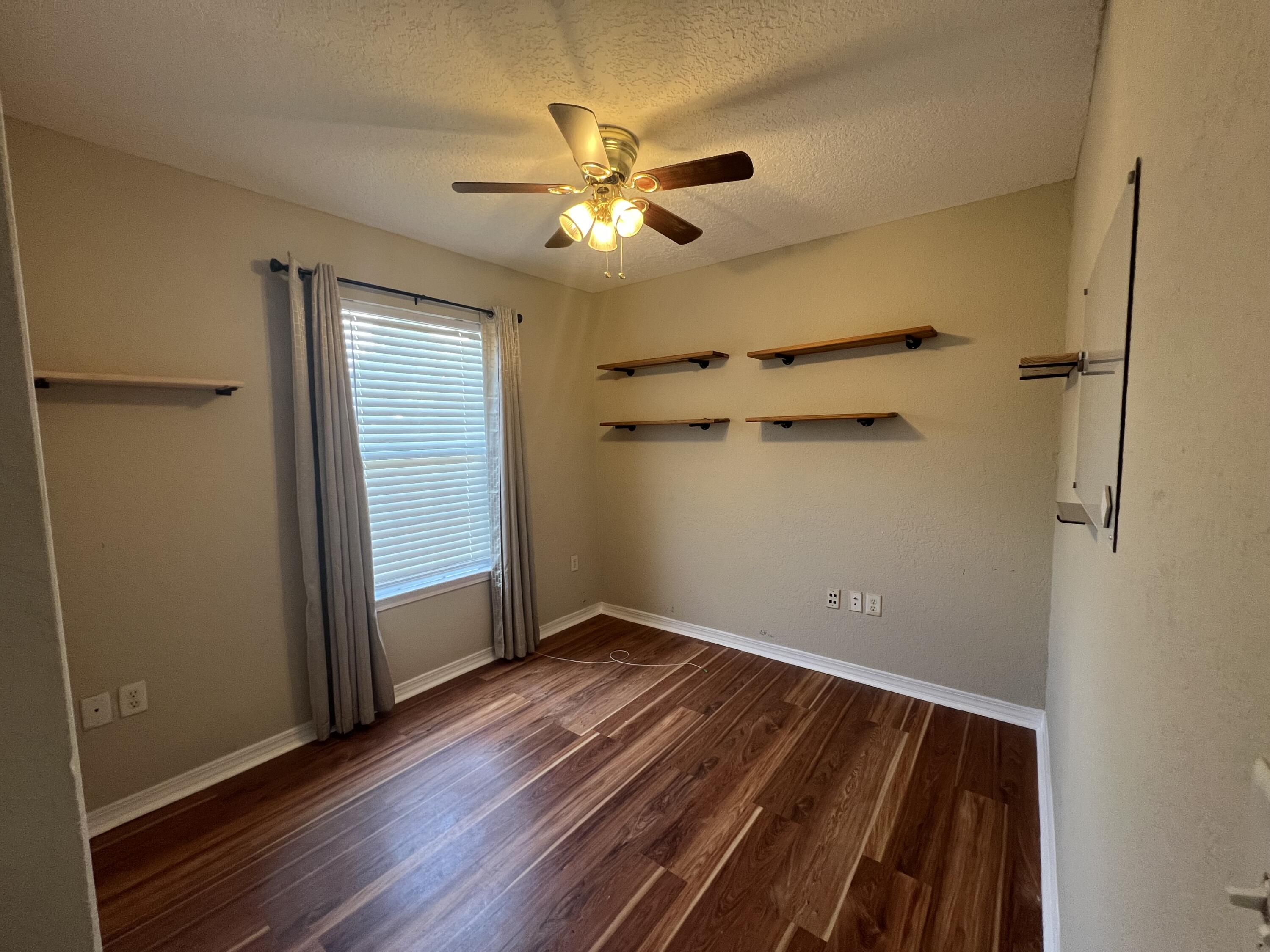 2864 Shoffner Avenue Crestview, FL 32539 - Photo 15 of 29 an empty room with wooden floor closet and windows
