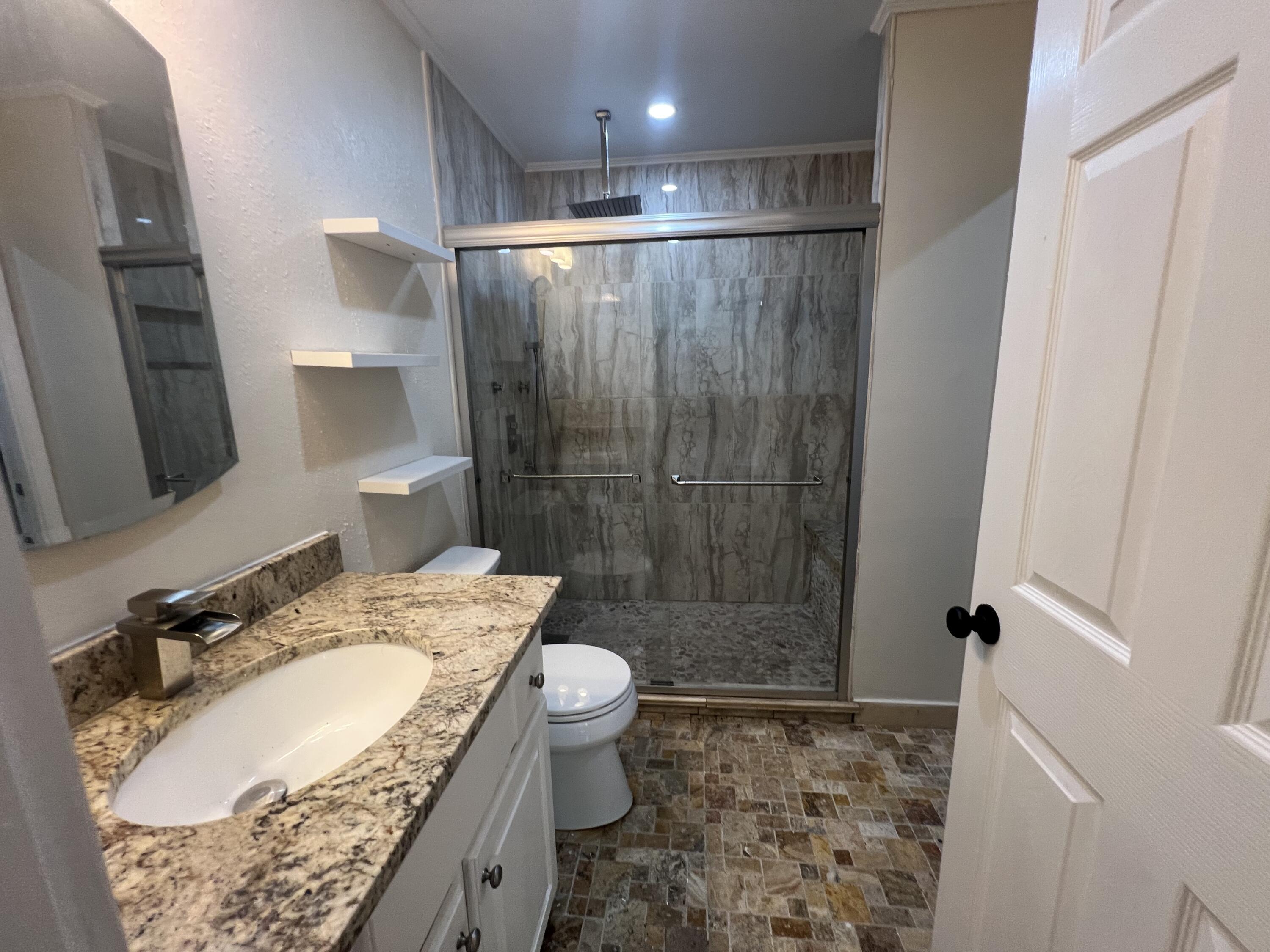 2864 Shoffner Avenue Crestview, FL 32539 - Photo 18 of 29 a bathroom with a granite countertop sink a mirror a toilet and shower