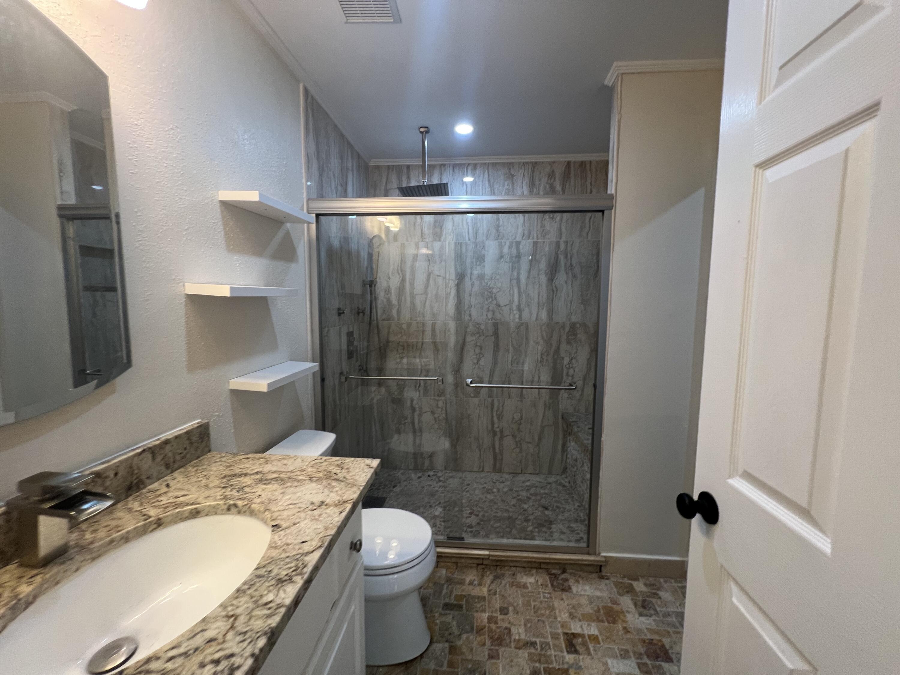 2864 Shoffner Avenue Crestview, FL 32539 - Photo 19 of 29 a bathroom with a granite countertop sink toilet a mirror and shower