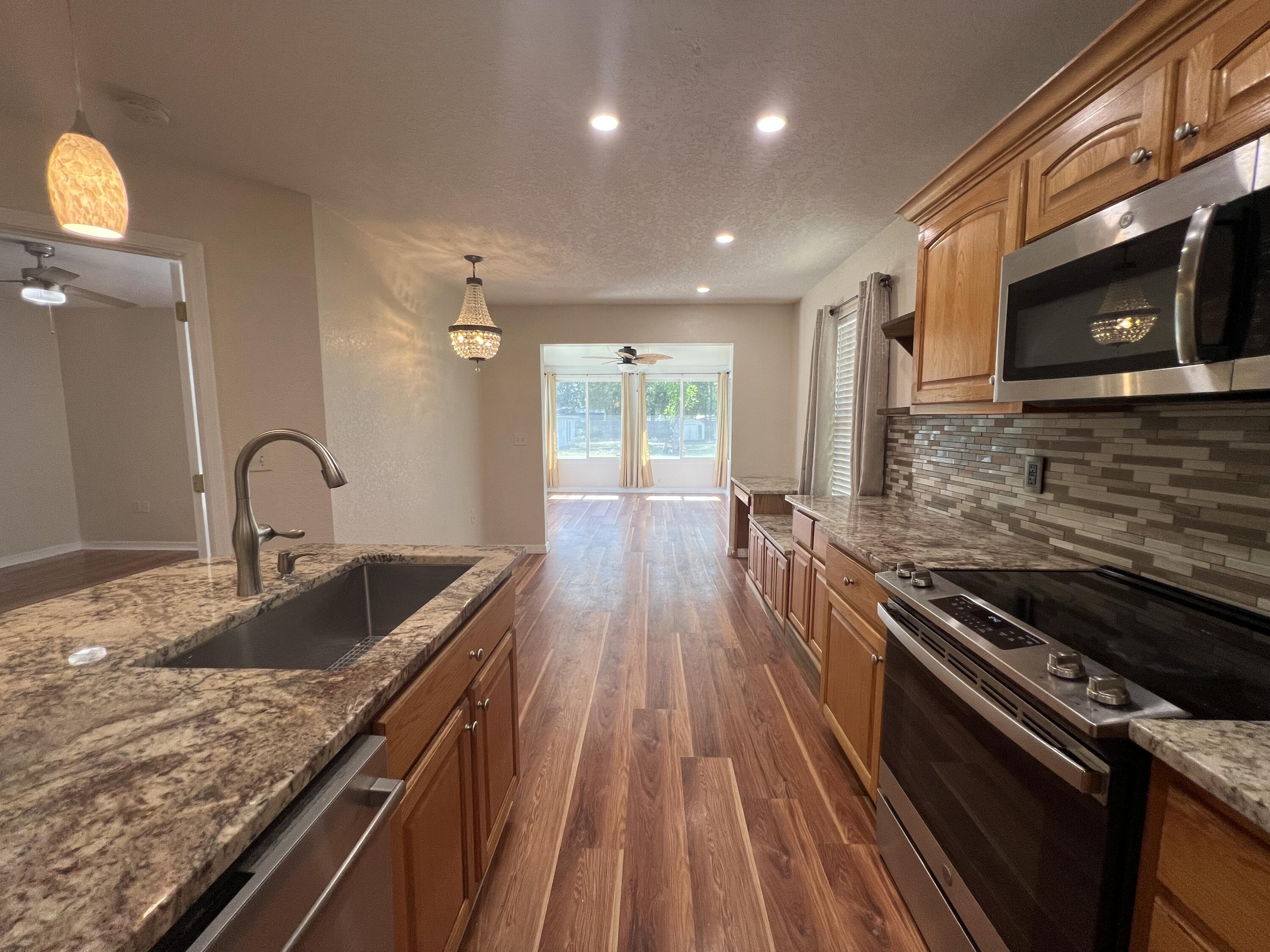 2864 Shoffner Avenue Crestview, FL 32539 - Photo 7 of 29 a kitchen with kitchen island granite countertop a stove and a sink