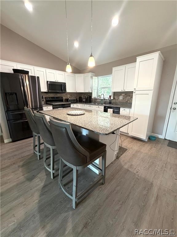 13591 Southwest 112th Street Dunnellon, FL 34432 - Photo 3 of 24 a kitchen with kitchen island a white counter top space stainless steel appliances and cabinets