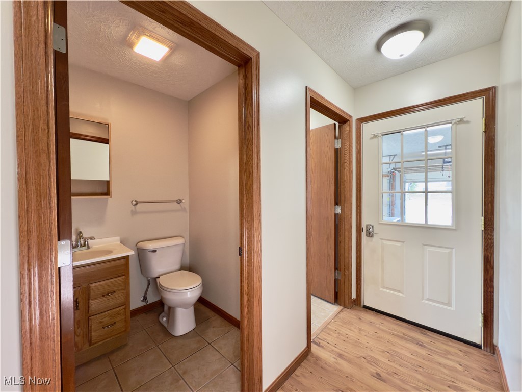 2109 Bell Road Vincent, OH 45784 - Photo 18 of 49 Half bathroom with a textured ceiling, vanity, and light wood-type flooring