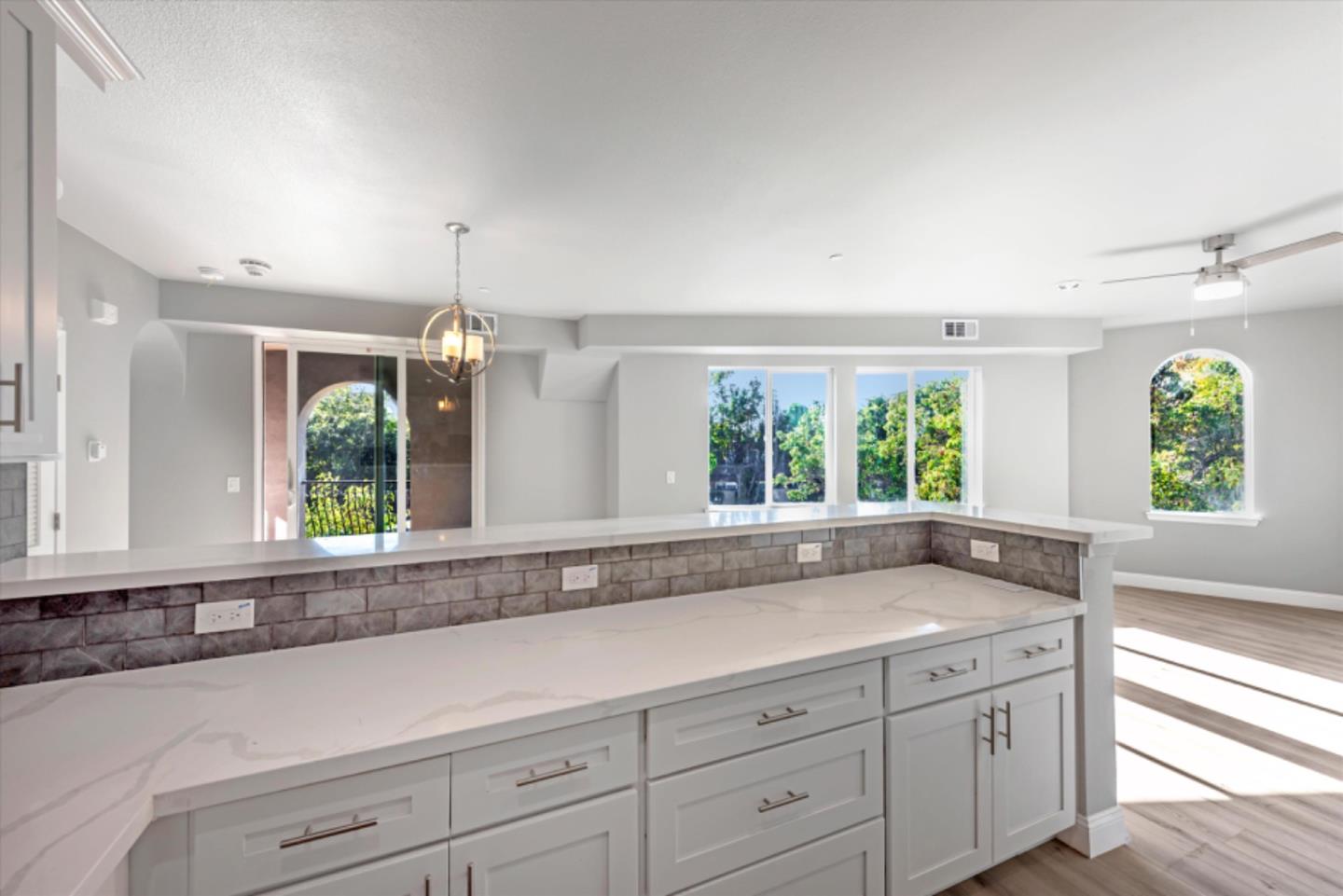 823 West A Street, Unit 2 Hayward, CA 94541 - Photo 4 of 8 a living room with kitchen island granite countertop a large window sink and cabinets