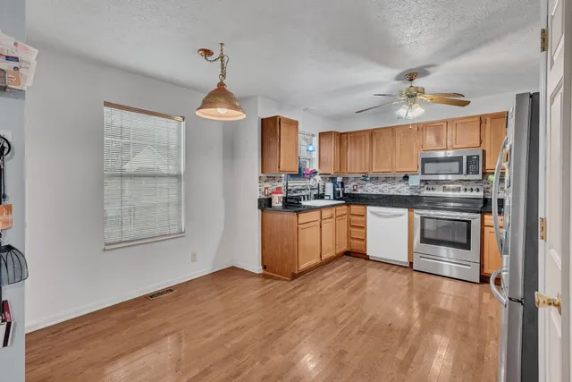 a view of a livingroom with a fireplace a chandelier and wooden floor