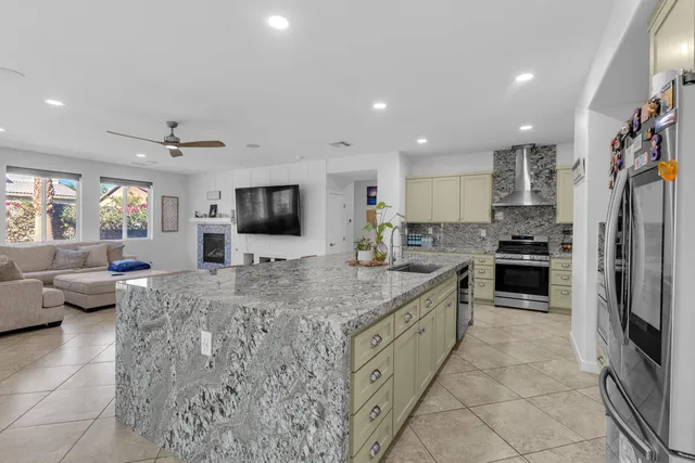 a kitchen with granite countertop a refrigerator and a sink
