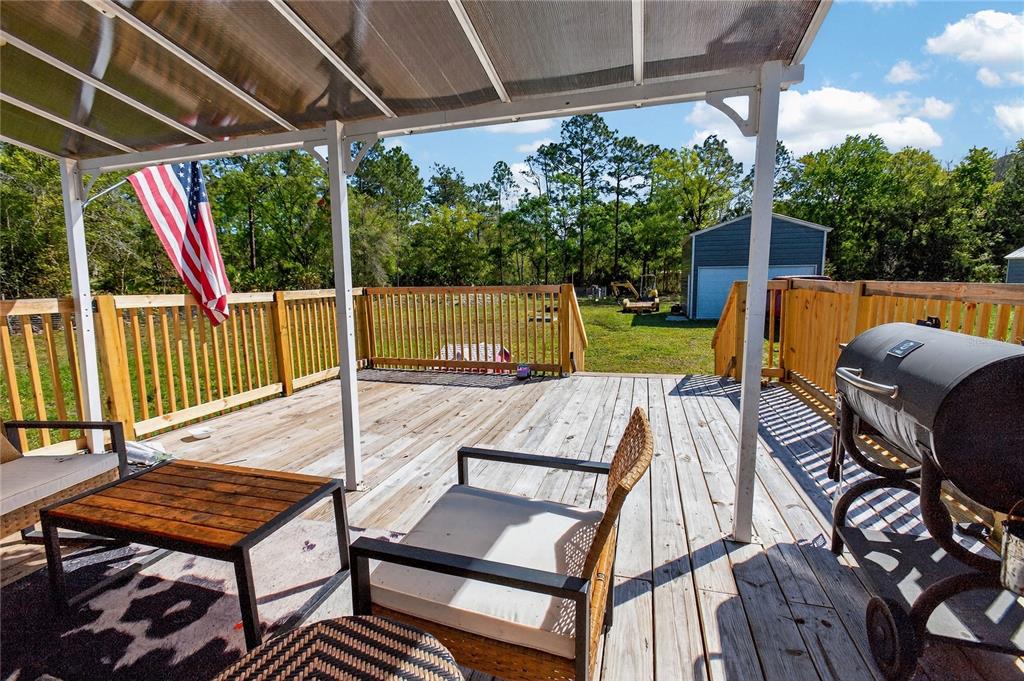 2857 Hickory Street Bunnell, FL 32110 - Photo 17 of 22 a view of a patio with a table chairs and a backyard