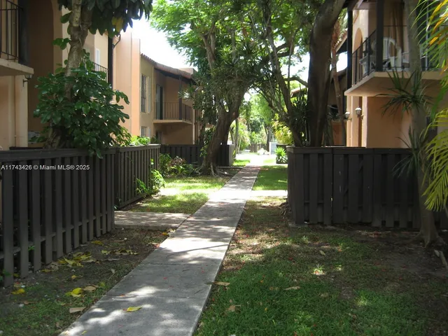 a view of a yard with wooden fence