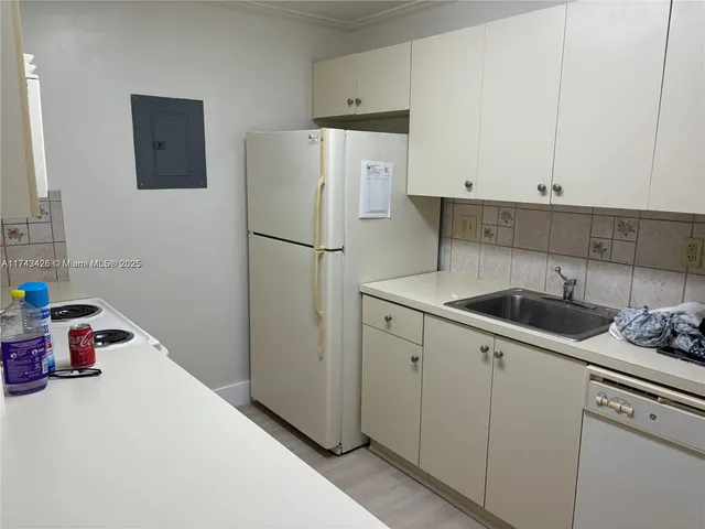 a kitchen with a refrigerator sink and cabinets