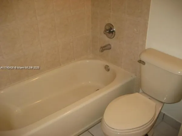 a white toilet sitting next to a bath tub