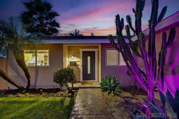 a view of a house with a small yard and potted plants