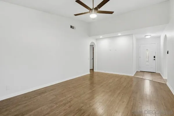an empty room with wooden floor and windows