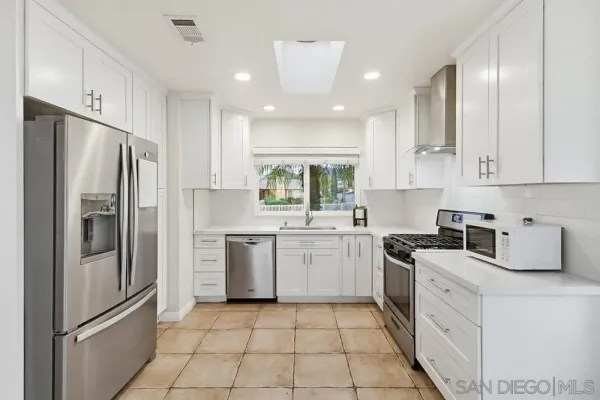a kitchen with white cabinets stainless steel appliances and sink