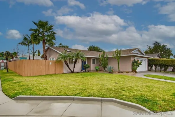 a view of a big house with a yard and plants