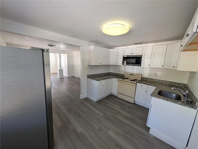 a kitchen with a sink a stove a microwave and cabinets