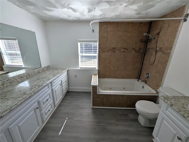 a bathroom with a granite countertop toilet a sink and bathtub