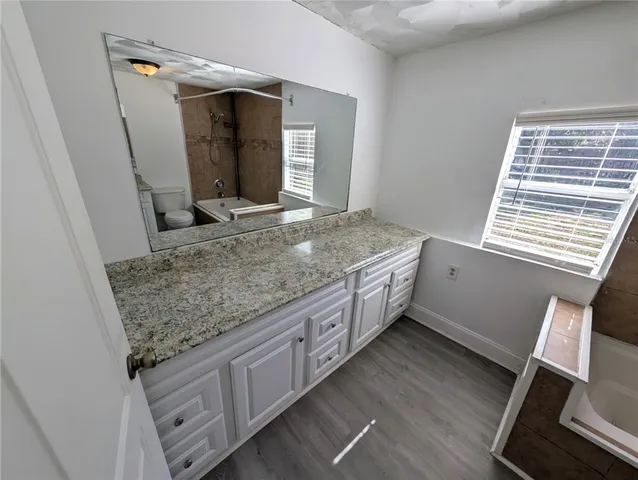 a bathroom with a granite countertop sink and a mirror