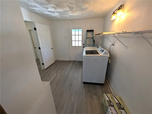 a view of a kitchen with wooden floor and electronic appliances