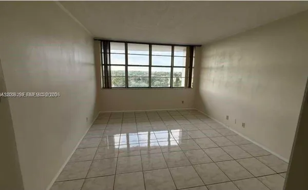 an empty room with white walls and tiles