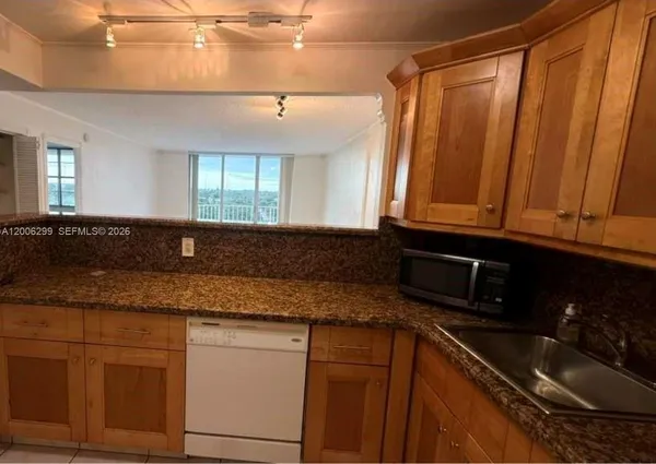 a kitchen with granite countertop a sink and cabinets
