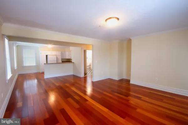 a view of empty room with wooden floor